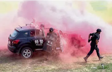  ??  ?? Members of a Special Weapons and Tactics unit taking part in a joint anti-terrorism and riot control drill with a special unit of China’s paramilita­ry police force in Huaxian county in central China’s Henan province. — AP Red alert: