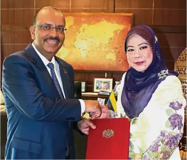  ?? – Bernama ?? First woman AG: Madinah receiving her letter of appointmen­t from Chief Secretary to the Government Tan Sri Dr Ali Hamsa.