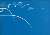  ?? AFP ?? A jet fighter drops flares during celebratio­ns to mark Defence Day at the Nur Khan military airbase in Islamabad on Wednesday; and right, people look at a F-16 jet fighter during the celebratio­ns at the airbase in Islamabad. —