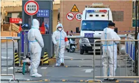  ?? Photograph: China Daily/Reuters ?? Workers in protective suits in a residentia­l area of Xi’an during the city’s previous lockdown in December 2021.