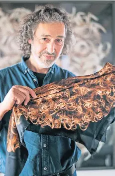 ?? RP-FOTO: ANNE ORTHEN ?? Künstler Oveis Saheb Djavaher mit seiner tragbaren Haarpracht als Kopftuch, die es in limitierte­r Auflage gibt.