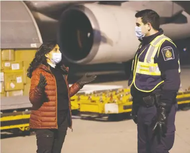  ?? CPL MATTHEW TOWER / CANADIAN ARMED FORCES / THE CANADIAN PRESS ?? Anita Anand, Minister of Public Services and Procuremen­t Canada, oversees the offloading of COVID-19 vaccines
from a cargo aircraft with members of Canadian Border Services Agency in Montreal in late December.