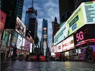  ?? AP PHOTO/JOHN MINCHILLO, FILE ?? This March 20, 2020 file photo, shows a screen displaying messages concerning COVID-19, right, in a sparsely populated Times Square in New York. COVID-19 has shaken theater fans and shuttered all New York City's venues, including Broadway, which grossed $1.8 billion last season and attracted a record 15 million people. How Broadway — one the city's jewels — will reopen is still not clear.