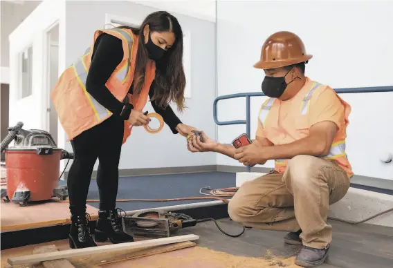  ?? Jessica Christian / The Chronicle ?? Vanessa Mejia, a beneficiar­y of the Deferred Action for Childhood Arrivals program, works with her father, Julio Mejia, at a Berkeley constructi­on site.