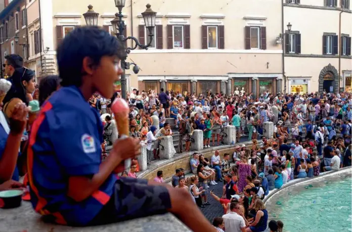  ?? ?? The gelato-sticky masses trying to keep cool around the Trevi Fountain in Rome in July.