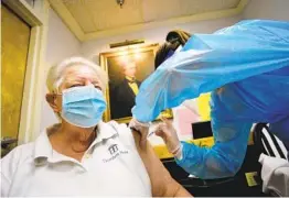  ?? KRISTOPHER RADDER AP ?? Kathleen Sawtelle, a pharmacist with Health Direct, gives Pfizer’s COVID-19 vaccine to Sandy Merkle, 81, a registered nurse, in Brattlebor­o, Vt., on Tuesday.