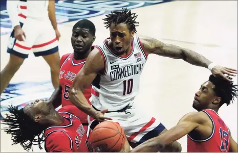  ?? David Butler II / Associated Press ?? UConn guard Brendan Adams (10) fouls St. John’s guard Posh Alexander, left foreground, in the first half on Monday in Storrs.