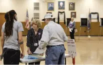  ?? JONATHON GRUENKE/STAFF FILE ?? Susie Henriksen, center, assists voters inside the Knights of Columbus building in the Boulevard precinct in November in Newport News.