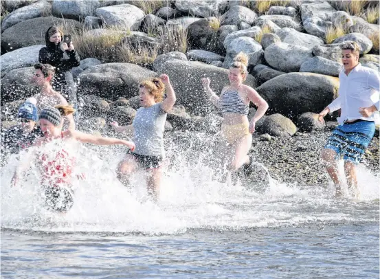  ?? Kathy Johnson ?? Participan­ts in the fifth annual Lobster Dip make the dash into the frigid Atlantic at the North East Point waterfront on Cape Sable Island on Nov. 24.