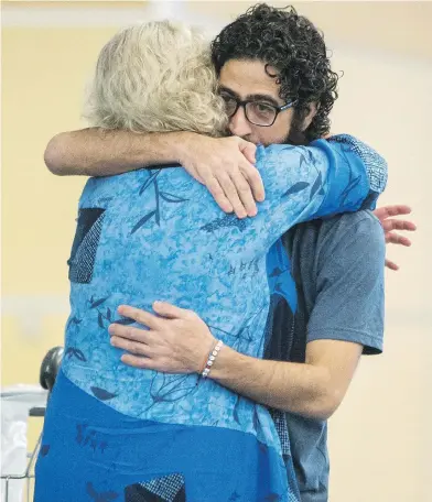  ?? BEN NELMS / THE CANADIAN PRESS ?? Hassan Al Kontar hugs Laurie Cooper after arriving in Vancouver on Monday.