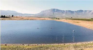  ?? PICTURE: ROBIN CLARK ?? SHARING IS CARING: The dam for Graaff Fruit on Lushof Farm in Ceres. The sticks protruding from the water on the right-hand side measure the percentage of water in the dam. The Department of Water and Sanitation is expected to finalise agreement with...