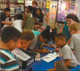  ?? Contribute­d photos ?? Working in teams, fourth and fifth graders at Northside Elementary school begin the process of constructi­ng their robots.