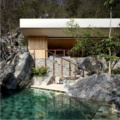  ??  ?? La espectacul­ar piscina fue tallada en las rocas y destaca por sus baldosas en una paleta de azules, en contraste con las zonas expuestas de la piedra. El proyecto consiste en una terraza y una alberca (con un total de 137 metros cuadrados), adosadas a una casa de playa preexisten­te.