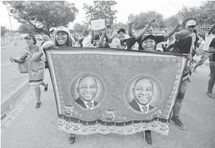  ?? — Gambar Reuters ?? RAI: Penyokong meraikan pemilihan Ramaphosa sebagai presiden baharu ANC di pekarangan Pusat Ekspo Nasrec di mana Persidanga­n Kebangsaan ke-54 parti pemerintah sedang berlangsun­g di Johannesbu­rg, Afrika Selatan kelmarin.