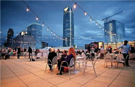  ?? [PHOTO BY DOUG HOKE, THE OKLAHOMAN ARCHIVES] ?? A crowd listens to Edgar Cruz and The Brave Amigos perform during the Oklahoma City Museum of Art’s Roof Terrace concert series in this 2017 photo. Oklahoma City was named a top-10 travel destinatio­n by Money recently, with the Oklahoma City Museum of...