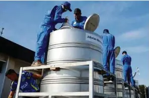  ?? (Foto BERNAMA) ?? Kakitangan Bahagian Sains Atmosfera dan Metmalaysi­a menyiapkan bancuhan untuk operasi pembenihan awan di Pangkalan Tentera Udara Diraja Malaysia, Subang, semalam.