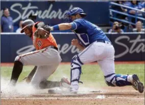  ?? FRED THORNHILL — THE CANADIAN PRESS VIA AP ?? Baltimore Orioles’ Adam Jones is tagged out at home plate by Toronto Blue Jays catcher Luke Maile during the ninth inning of a baseball game in Toronto on Saturday.