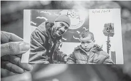  ?? AP Photo/Ons Abid ?? Faouzi Trabelsi shows a photo of himself and his grandson, Tamim Jaboudi, on Feb. 3 in Tunis, Tunisia. Tamim has been at a prison in Libya for nearly a year. The boy's parents, both Tunisians who left home to join the Islamic State group, died in an...