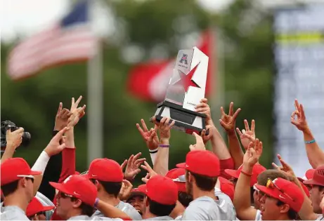  ?? Tim Warner photos ?? Houston players hoist the American Athletic Conference regular-season championsh­ip trophy in celebratio­n after beating Cincinnati 7-6 on Saturday at Schroeder Park to finished tied with Central Florida for first place in the standings.