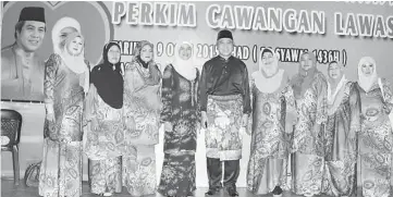  ??  ?? Awang Tengah (centre) and Dayang Morliah (fourth left) pose with the exco members of Perkim Lawas during their Hari Raya gathering.