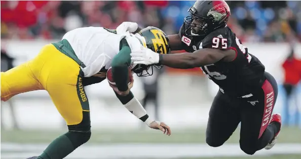  ?? THE CANADIAN PRESS/TODD KOROL ?? Edmonton Eskimos quarterbac­k Mike Reilly is taken down by the Calgary Stampeders’ Ja’Gared Davis during Sunday’s West final at McMahon Stadium. Despite throwing for 348 yards and a touchdown, Reilly and the Esks couldn’t maintain their early momentum.