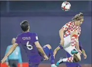  ??  ?? El croata Luka Modric le gana un balón aéreo al griego Alexandros Tziolis, ayer