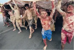  ?? AP ?? Indigenous protesters painted with red ink and clay, representi­ng spilled blood and gold, march against mining activities April 11 at the Ministry of Mines and Energy in Brasilia, Brazil.