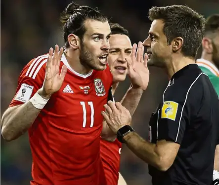  ??  ?? It wasn’t my fault: Wales’ Gareth Bale arguing with referee Nicola Rizzoli before getting booked in the 2018 World Cup qualifier against Ireland in Dublin on Friday. — Reuters