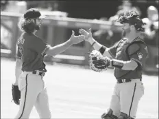  ?? CURTIS COMPTON /AP ?? ARIZONA DIAMONDBAC­KS STARTING PITCHER ZAC GALLEN (left) celebrates with catcher Stephen Vogt during the 7th inning of the first game of a double header against the Atlanta Braves Sunday in Atlanta.