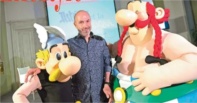  ?? — AFP ?? BOLOGNE: French comics writer, designer and colorist Jean-Yves Ferri poses yesterday with characters Asterix (left) and Obelix after a press conference in Bologne.