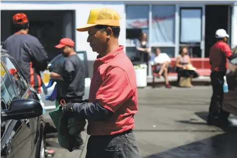  ?? Brandon Chew / The Chronicle 2015 ?? Employees of Divisadero Touchless Carwash dry cars. A developmen­t with affordable housing has been proposed for the site.