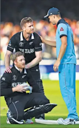  ??  ?? New Zealand’s Martin Guptill (L) and Jimmy Neesham (C) being consoled by England’s Chris Woakes after the World Cup final Super Over at Lord's in July. GETTY IMAGES