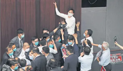  ?? REUTERS ?? A pro-democratic legislator scuffles with security and pro-China legislator­s during the Legislativ­e Council’s house committee meeting yesterday.