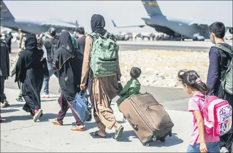  ?? SGT. SAMUEL RUIZ — U.S. MARINE CORPS VIA AP ?? Families walk toward their flight Aug. 24during ongoing evacuation­s at Hamid Karzai Internatio­nal Airport, Kabul, Afghanista­n.