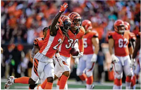  ?? BOBBY ELLIS / GETTY IMAGES ?? The Bengals’ Dre Kirkpatric­k and Jessie Bates (30) celebrate after Bates intercepte­d a pass from Ryan Tannehill of the Miami Dolphins during the fourth quarter at Paul Brown Stadium on Sunday in Cincinnati. Cincinnati won 27-17.