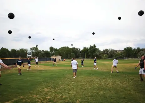  ?? Photos by Hyoung Chang, The Denver Post ?? Mullen football players work out — socially distanced — with medicine balls at practice on Thursday.