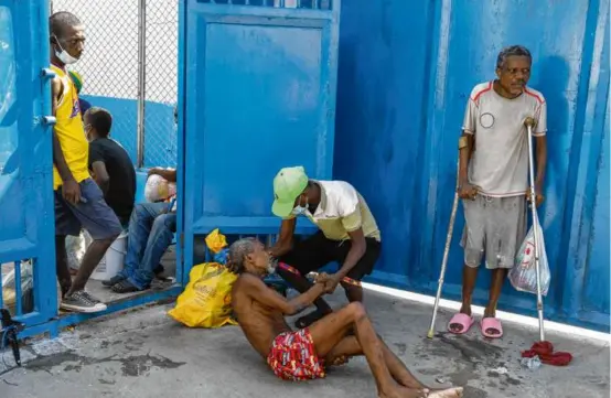  ?? ODELYN JOSEPH/ASSOCIATED PRESS ?? An inmate aided another prisoner inside Haiti’s National Penitentia­ry on Sunday after the prison was attacked by armed gangs.