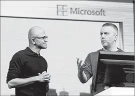  ?? Jeff Chiu Associated Press ?? MICROSOFT’S shift in tone came after Satya Nadella was promoted to CEO last year. Above, he is shown at left with program manager Rob Lefferts in April.