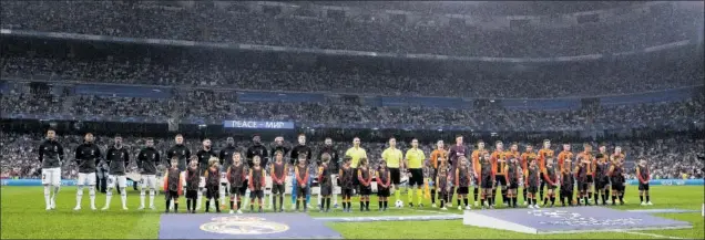  ?? ?? Los dos equipos posan antes de arrancar el partido, mientras escuchan el himno de la Champions en presencia de 56.011 espectador­es en el Bernabéu.