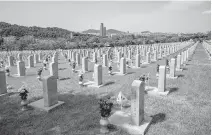  ?? Korea Times photo by Shim Hyun-chul ?? National flags are placed near tombstones at the Seoul National Cemetery in Dongjak District, Seoul, June 5, 2023, a day before Memorial Day.