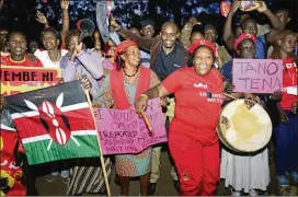  ?? JOHN MUCHUCHA / ASSOCIATED PRESS ?? Supporters of Kenyan President Uhuru Kenyatta hold up posters as they celebrate his victory Monday in Nairobi, Kenya. Kenyatta collected 98 percent of the vote in an election that exposed the East African country’s divisions.