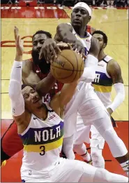  ??  ?? Eric Christian Smith
Pelicans guards Josh Hart (3) and Jrue Holiday, top, vie with the Rockets’s James Harden, center, for a rebound during the first half Feb. 2.