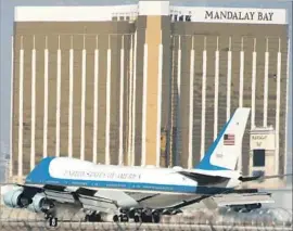  ?? Robyn Beck AFP/Getty Images ?? AIR FORCE ONE arrives at McCarran Internatio­nal Airport in Las Vegas, with the Mandalay Bay hotel, from where the gunman staged his attack, in the background. President Trump and the first lady visited victims and first responders.