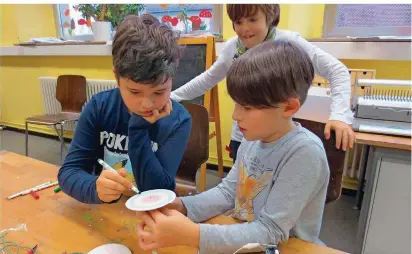  ?? FOTO: NICOLE PASCHEK ?? Konzentrie­rt beim Bierdeckel-Experiment mit Mini-Motor: Die St. Ingberter Montessori-Grundschül­er Sinan und Julio, im Hintergrun­d Theo.