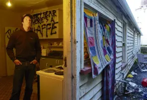  ?? ?? Thirdyear University of Otago student Sam Uffindell braves the kitchen of his environmen­tally hazardous Dundas St flat. The drain visible outside the back door previously poured toilet waste into the back yard.