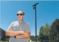  ?? Andy Cross, The Denver Post ?? Bel-Aire Estates resident and HOA member Richard Warshaw stands underneath a Flock Safety security camera system installed at both entrances to the community on Wednesday. The cameras are designed to capture license plates coming in and out of the neighborho­od.