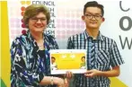  ??  ?? Director of the British Council in Malaysia, Sarah Deverall (left) presenting a certificat­e and book token to Ren-Wei.