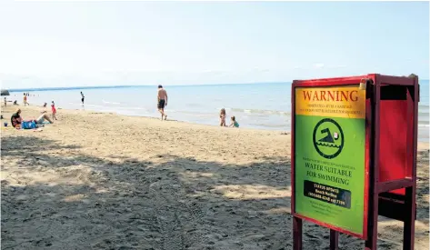  ?? ALLAN BENNER/STANDARD STAFF ?? After being underwater for much of the summer and posted as unsafe for swimming, Lakeside Park's beach was open on Friday.