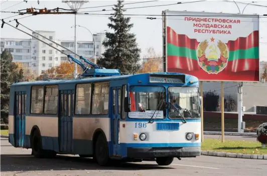  ?? ?? ► Un viejo trolebus pasa cerca de un póster apoyando la independen­cia de Transnistr­ia en Tiráspol.