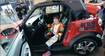  ?? ZHANG TAO / FOR CHINA DAILY ?? A girl sits in a new energy car during an industry expo in Zhengzhou, capital of Henan province.